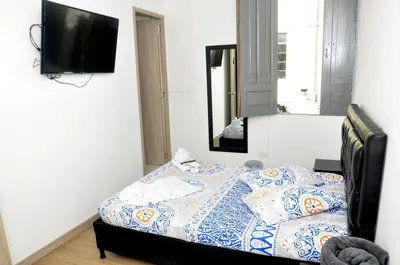a bedroom with a bed and a tv on a wall at El ensueño in Manizales