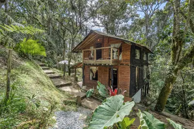 a wooden house in the middle of a forest at Cabañas Casa Monte en Santa elena in Medellín