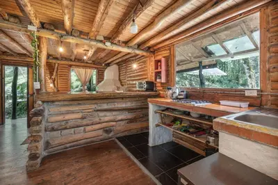 a kitchen in a log cabin with a sink at Cabañas Casa Monte en Santa elena in Medellín