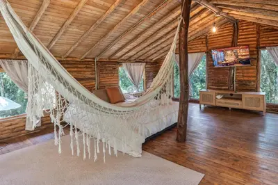 a bedroom with a hammock in a house at Cabañas Casa Monte en Santa elena in Medellín