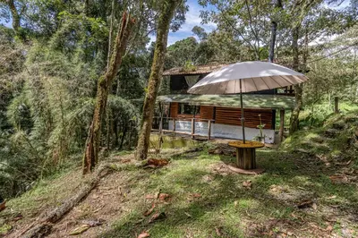 a house with an umbrella in the woods at Cabañas Casa Monte en Santa elena in Medellín