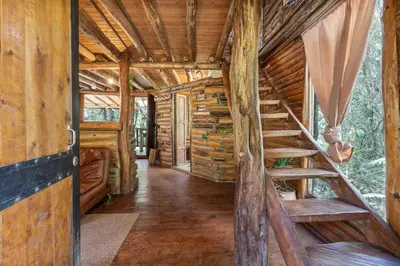an inside view of a log cabin with a wooden staircase at Cabañas Casa Monte en Santa elena in Medellín