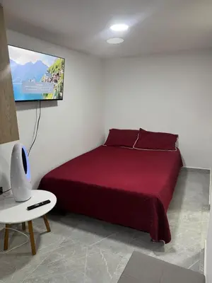 a bedroom with a bed with a tv on the wall at Villa Loreto Aparta estudio 203 in Medellín
