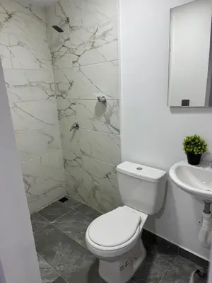 a white bathroom with a toilet and a sink at Villa Loreto Aparta estudio 203 in Medellín