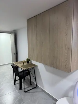 a table and a chair in a room at Villa Loreto Aparta estudio 203 in Medellín
