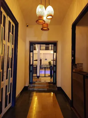 a hallway with a door and a chandelier at Hotel Colonial San Roque in San Roque