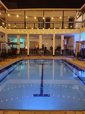 a large swimming pool in a hotel with lights on at Hotel Colonial San Roque in San Roque