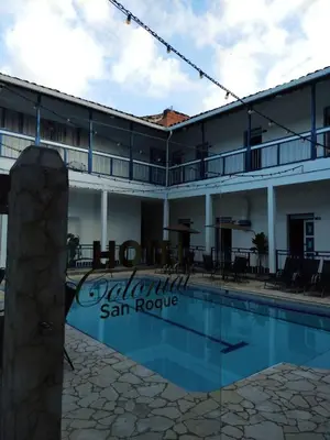 a hotel with a swimming pool in front of a building at Hotel Colonial San Roque in San Roque
