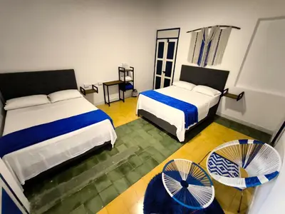 a hotel room with two beds and a fan at Hotel Colonial San Roque in San Roque