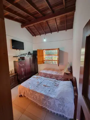 a bedroom with two beds and a television at Good Vibes El Víboral in Carmen de Viboral