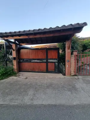 a garage with a red door and a fence at Good Vibes El Víboral in Carmen de Viboral