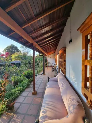 an outdoor patio with a large couch under awning at Good Vibes El Víboral in Carmen de Viboral
