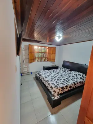 a bedroom with a bed and a wooden ceiling at Good Vibes El Víboral in Carmen de Viboral