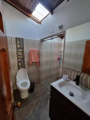 a bathroom with a toilet and a sink at Good Vibes El Víboral in Carmen de Viboral