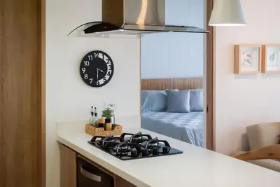 a kitchen with a stove and a clock on the wall at Altura y Confort en Envigado in Envigado