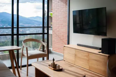 a living room with a television and a chair at Altura y Confort en Envigado in Envigado
