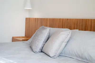 two pillows on a bed with a wooden headboard at Altura y Confort en Envigado in Envigado