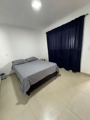 a bedroom with a bed with a blue curtain at Hermoso Apartamento Amoblado in Aguadas