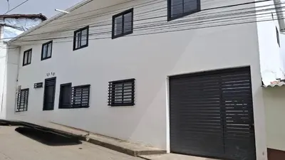 a white building with black garage doors on it at Hermoso Apartamento Amoblado in Aguadas