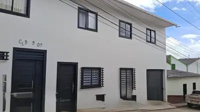 a white building with black doors and windows at Hermoso Apartamento Amoblado in Aguadas