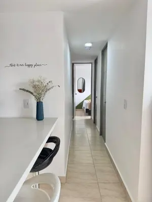 a hallway with white walls and a white desk with a chair at Apartamento Moderno Sabaneta Wifi 600mb in Sabaneta