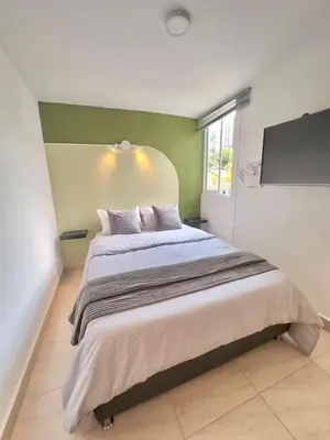 a bedroom with a large bed and a window at Apartamento Moderno Sabaneta Wifi 600mb in Sabaneta