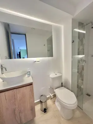 a bathroom with a toilet and a sink and a mirror at Apartamento Moderno Sabaneta Wifi 600mb in Sabaneta