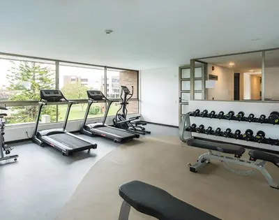 a gym with several treadmills and elliptical machines at Casagrande Apartahotel in Rionegro