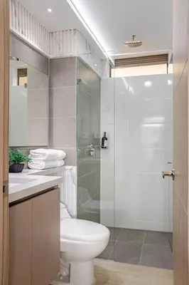 a bathroom with a toilet and a glass shower at Casagrande Apartahotel in Rionegro