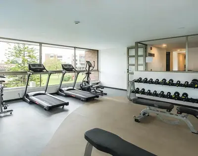 a gym with several treadmills and machines in a room at Casagrande Apartahotel in Rionegro
