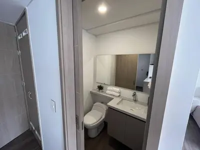 a bathroom with a sink and a toilet and a mirror at Casagrande Apartahotel in Rionegro