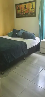 two beds with blue pillows in a bedroom at Apartamento céntrico en el poblado in Medellín