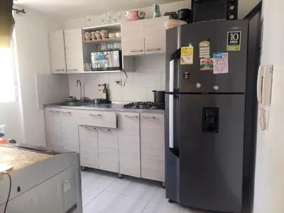 a kitchen with a black refrigerator and white cabinets at Apartamento céntrico en el poblado in Medellín