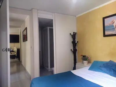 a bedroom with a blue and white bed and a hallway at Apartamento céntrico en el poblado in Medellín