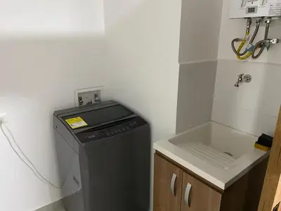 a small kitchen with a washing machine and a sink at Centro de negocios 3 33 in Medellín