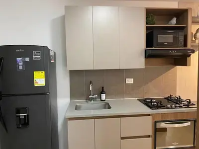 a kitchen with a sink and a refrigerator at Centro de negocios 3 33 in Medellín