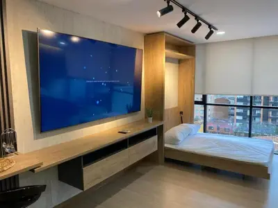 a bedroom with a large flat screen tv on a wall at Centro de negocios 3 33 in Medellín