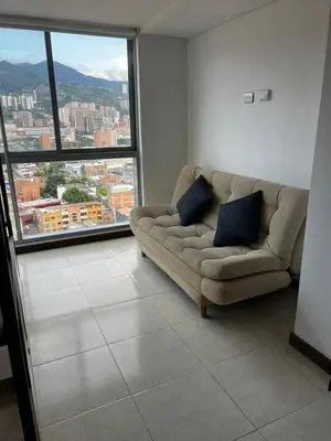 a living room with a couch and a large window at Apartamento Loft con vista unica in Itagüí