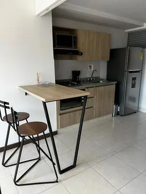 a kitchen with a wooden table and two chairs at Apartamento Loft con vista unica in Itagüí
