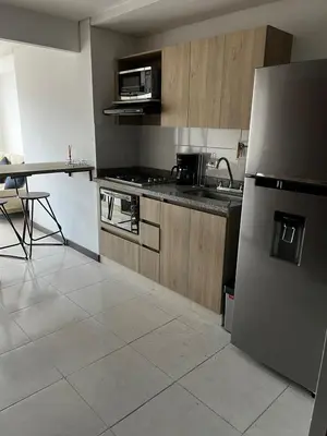 a kitchen with a stainless steel refrigerator and a table at Apartamento Loft con vista unica in Itagüí
