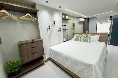 a bedroom with a large white bed and a tv at 1B Luxury Apartment San Javier medellin in Medellín