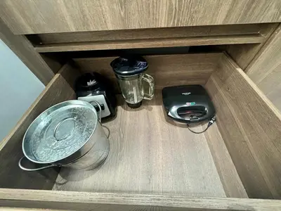 a drawer in a wooden cabinet with a food processor and a blender at 1B Luxury Apartment San Javier medellin in Medellín