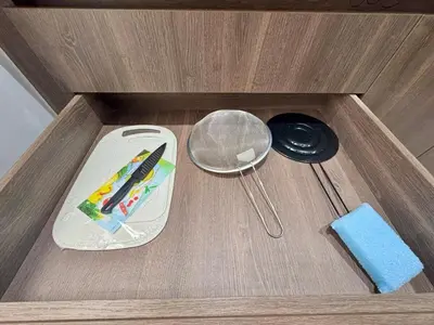 a wooden drawer with a knife and a strainer at 1B Luxury Apartment San Javier medellin in Medellín