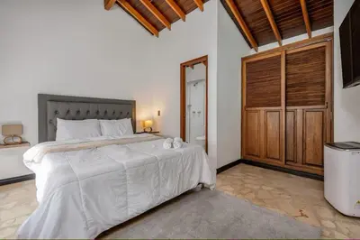 a bedroom with a large bed and a wooden closet at Urban 5th floor Living with AC unit 3Bed3bth no elevator 5 guests max in Envigado