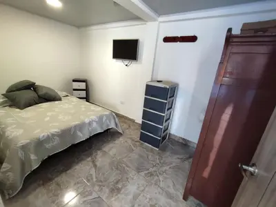 a bedroom with a bed and a tv on the wall at Alojamiento Betina in Salamina
