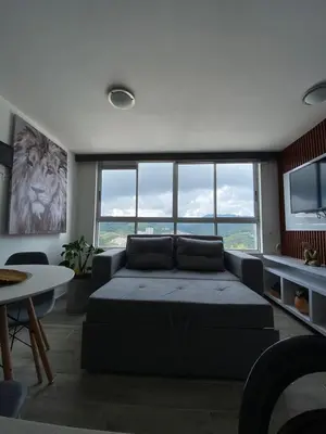 a living room with a bed and a large window at Modern APT Manizales in Manizales