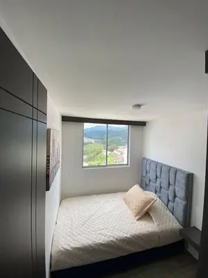 a small bedroom with a bed and a window at Modern APT Manizales in Manizales