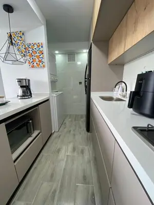 a kitchen with white counters and a black refrigerator at Modern APT Manizales in Manizales