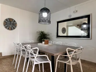 a dining room table with white chairs and a mirror at Exclusive Group Accomodation in Medellín