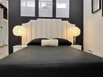 a bedroom with a large bed with two lamps at Exclusive Group Accomodation in Medellín